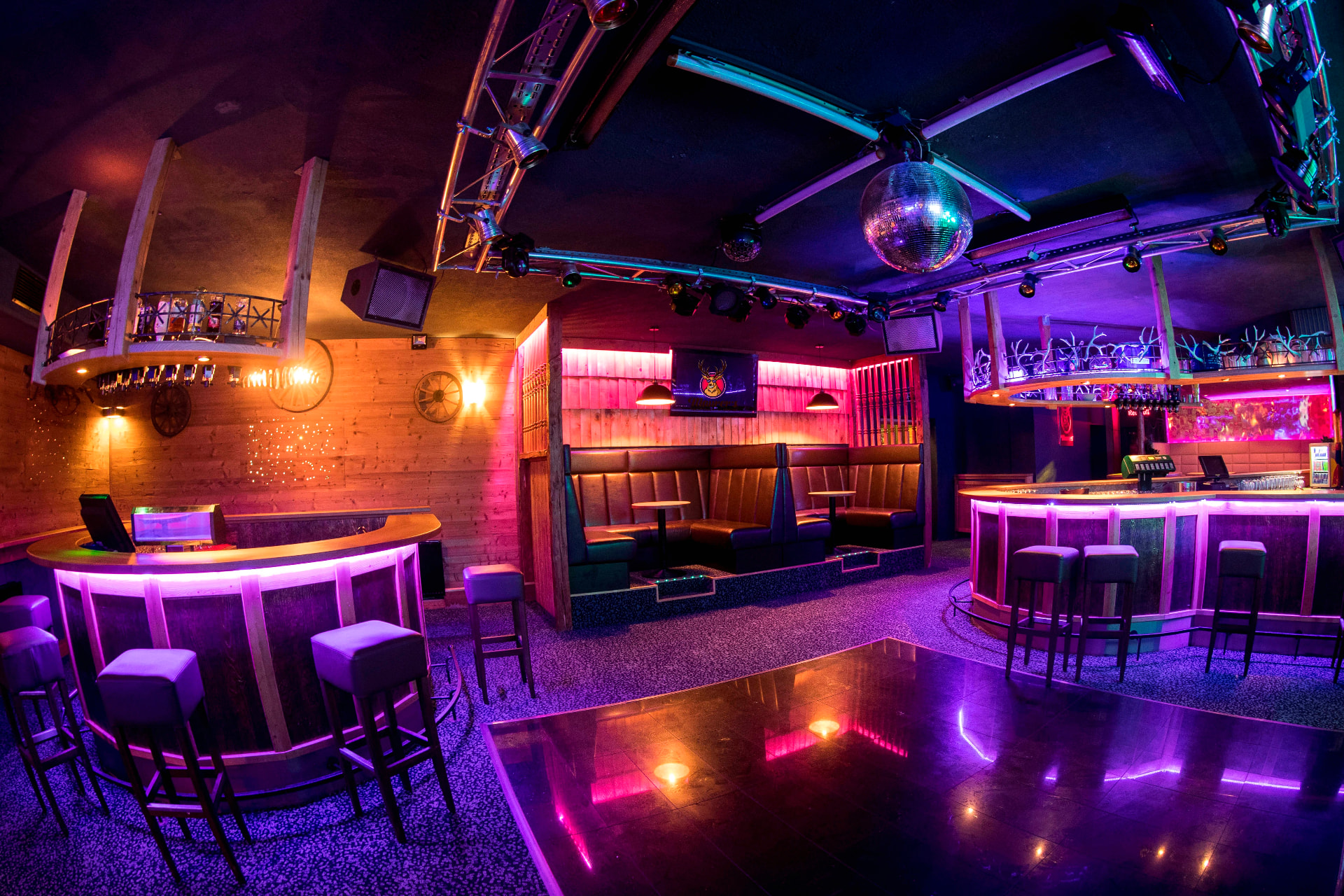 Maurer's Disco Bar mit beleuchteter Theke, Discokugel, lila Neonlicht und stimmungsvoller Clubatmosphäre